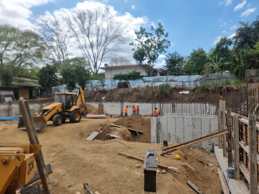 Retroexcavadora junto a los muros de concreto recién vaciados