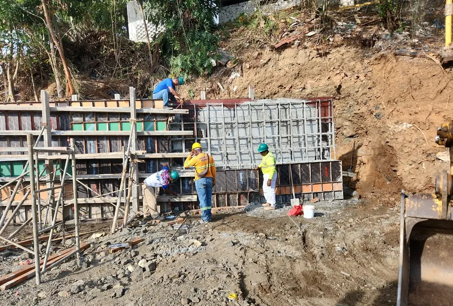 Obreros armando el encofrado del muro sobre el talud