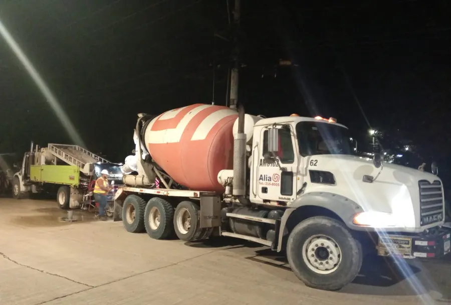 Camión mezclador vaciando concreto de noche en la obra